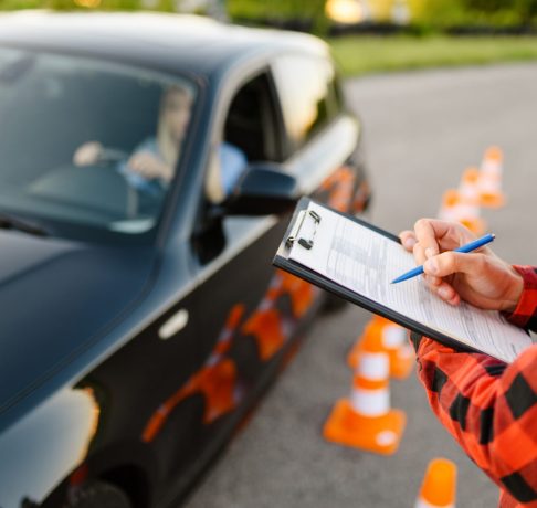 instructor-with-checklist-and-woman-in-car-exam-CJLLG52-e1596026626782