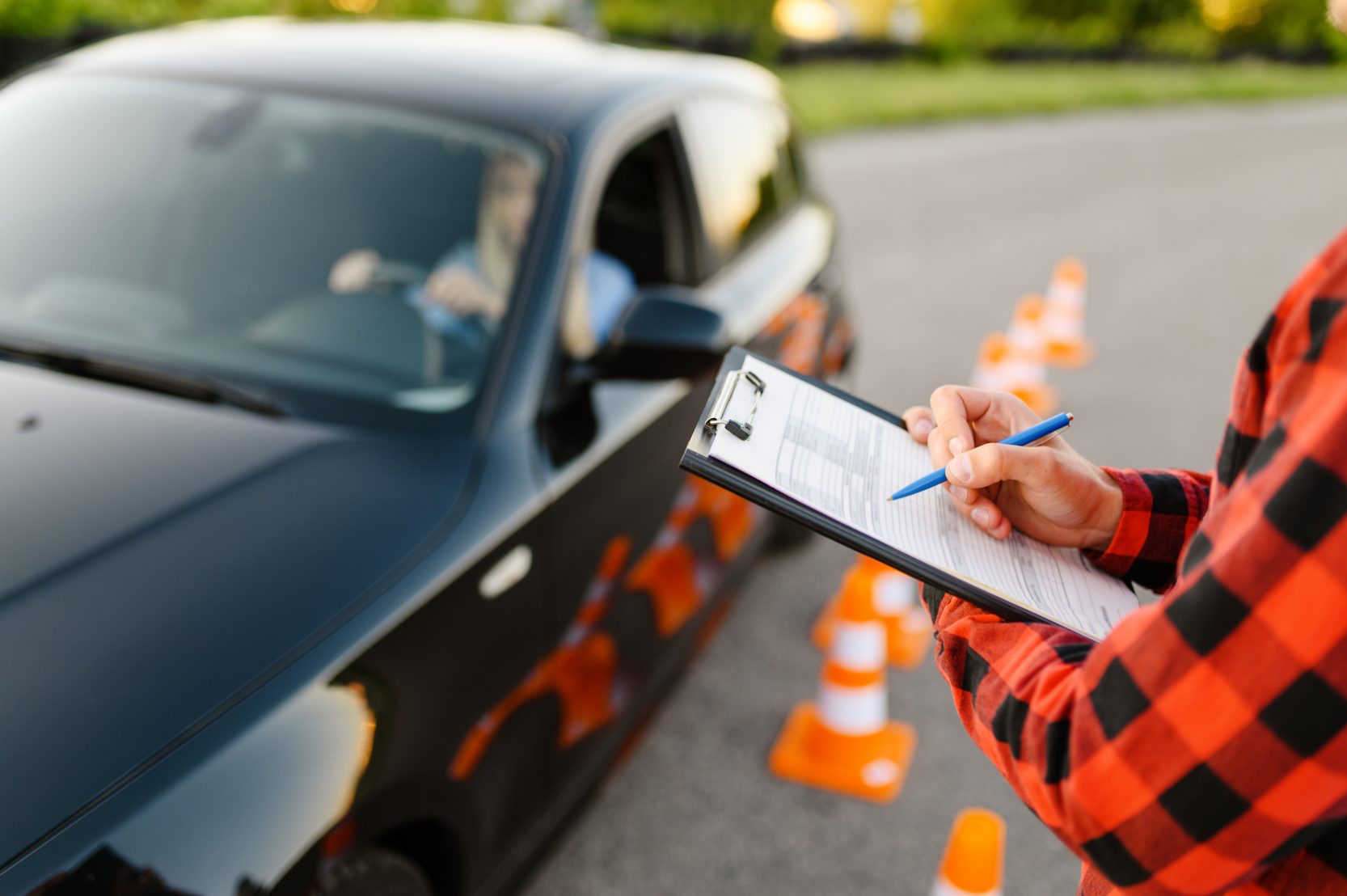 instructor-with-checklist-and-woman-in-car-exam-CJLLG52-e1596026626782